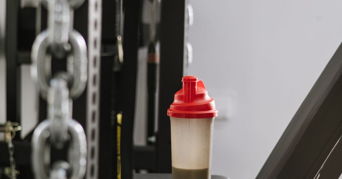 A shaker bottle on gym equipment with weight-stack chains behind it