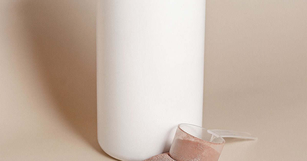 A white tub of protein powder with a scoop of chocolate-flavored powder