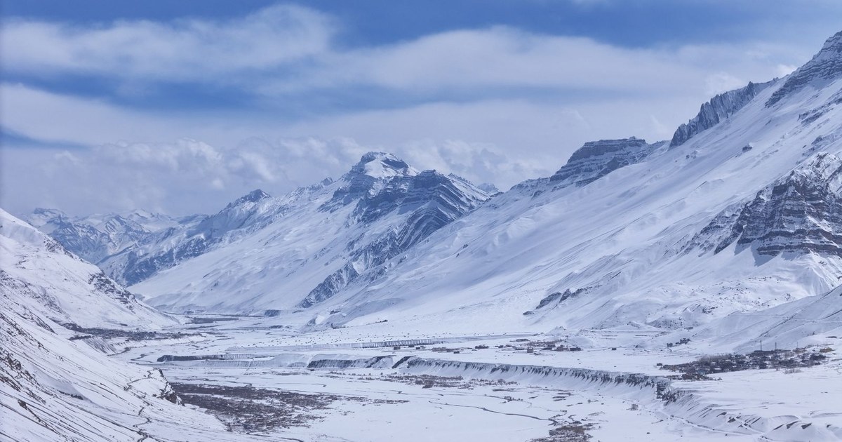 A snow-capped Himalayan mountain range and high-altitude valley