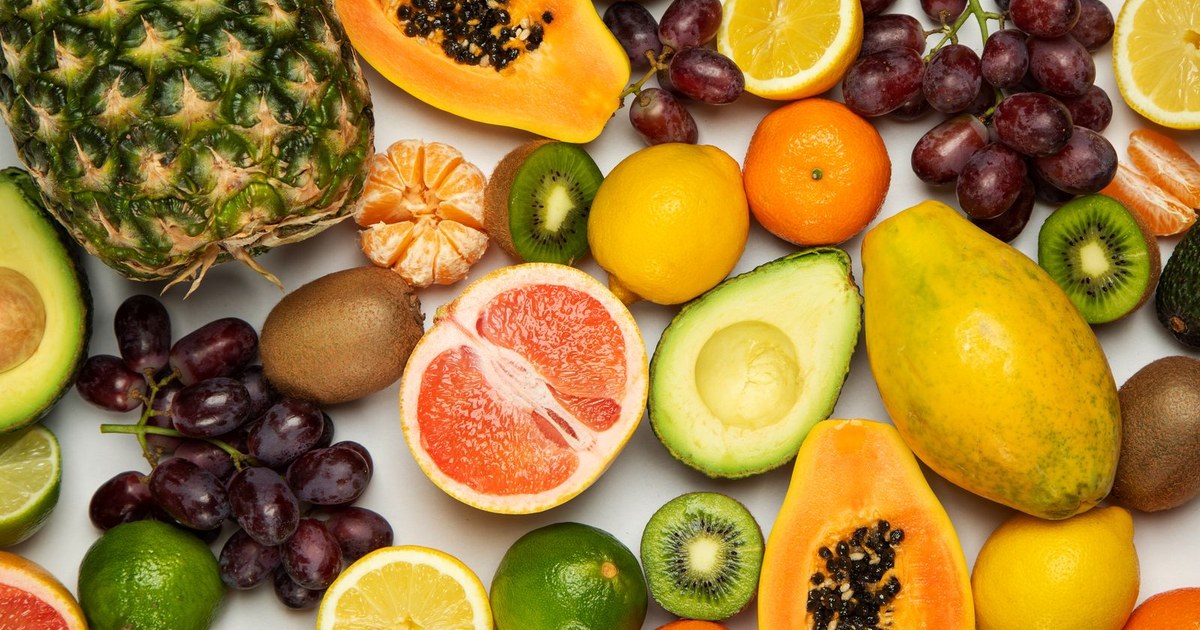 A colorful spread of fresh vitamin C-rich fruits including oranges, grapefruit, kiwi, and papaya