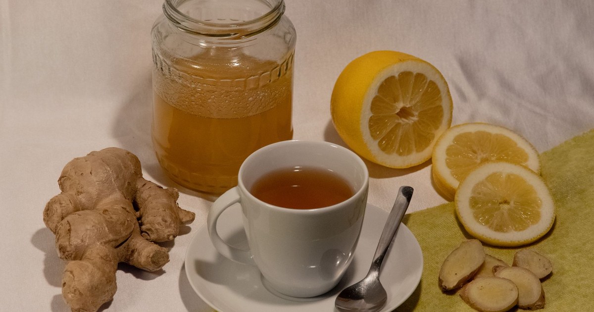 A cup of tea with honey, lemon, and fresh ginger