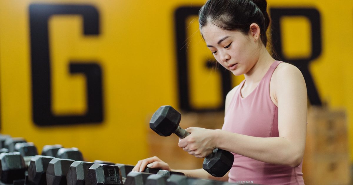 A woman lifting a dumbbell during a strength training workout