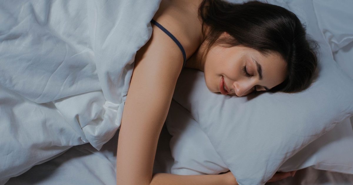 A woman sleeping peacefully in a cozy bed